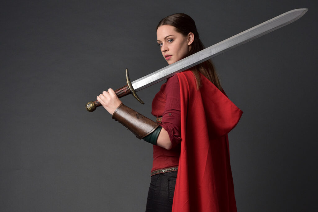 A red cloaked female fighter wielding a great big sword.